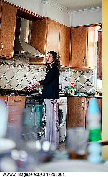 Lateinamerikanische Frau beim Kochen in der Küche zu Hause