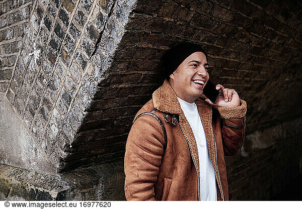 lateinamerikanischer Mann mittleren Alters  der fröhlich am Telefon spricht