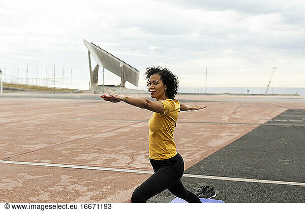 Lateinische Frau übt Yoga-Krieger-Pose im Freien