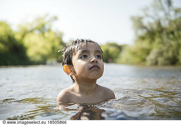 Latin child in peace enjoying summer in a river