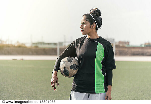 Latin woman football player holding a football.