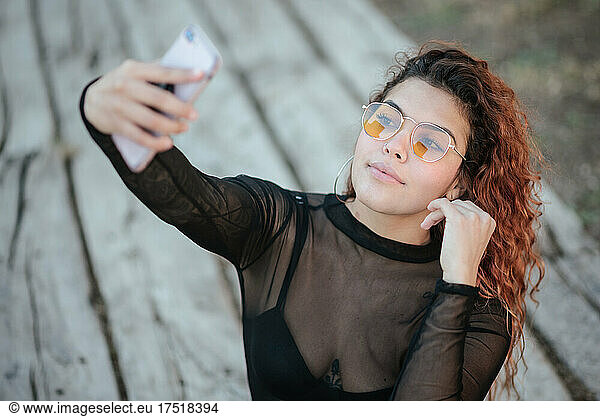 latin woman with glasses look at your mobile phone outdoors