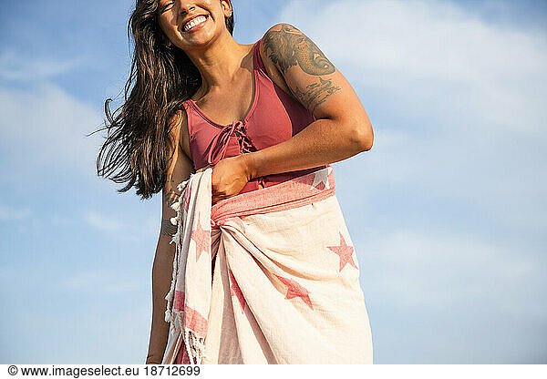 Latina woman having fun at the beach with towel wrap