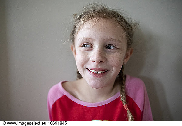 Laughing Blonde Girl With French Braids Looks Off Camera