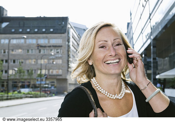 Laughing businesswoman talking in cellphone