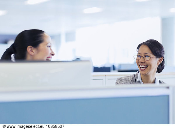 Laughing businesswomen talking in office
