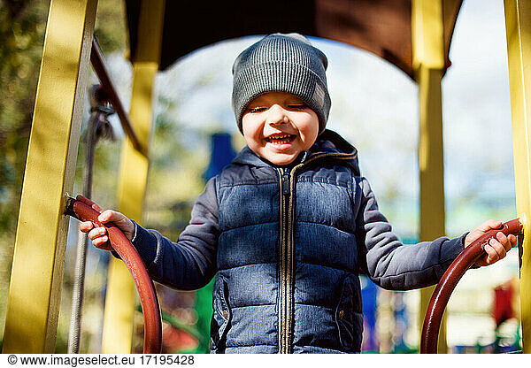 Laughing happy kid at playground  autumn outdoors activity