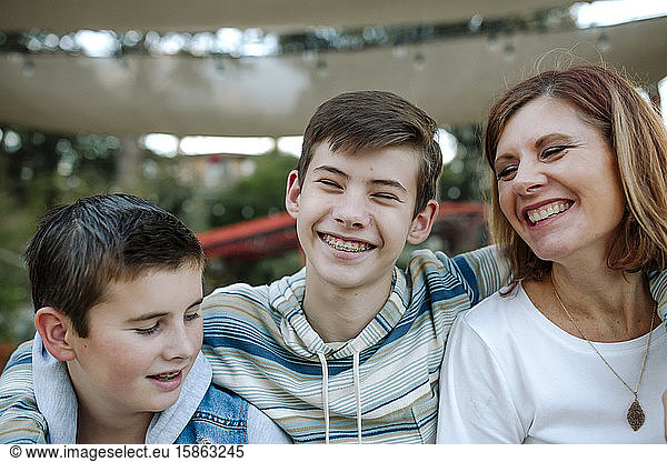 Laughing mom and teen sons with braces share joyful moment