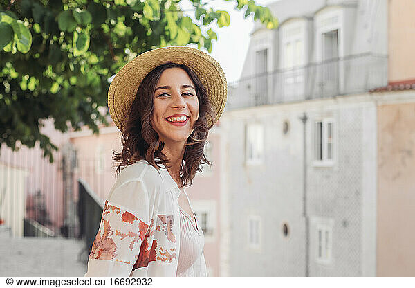 Laughing woman in a straw hat looking in the camera in Lisbon