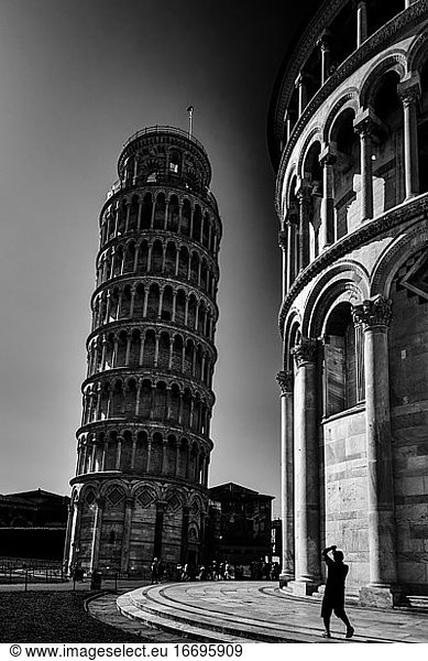 Leaning Tower of Pisa on black and white with tourist taking a picture