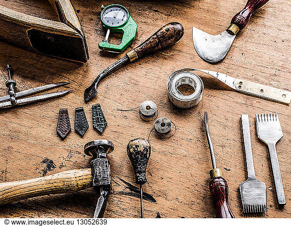 Leatherworker's workbench with hammer  tape measure and specialist tools  still life