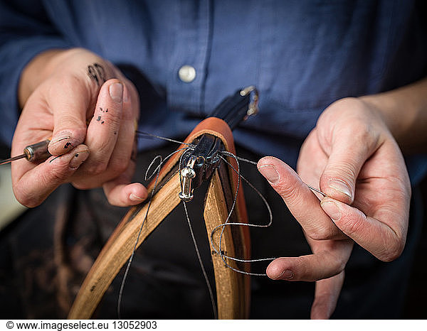 Leatherworker stitching handbag in workshop  close up of hands