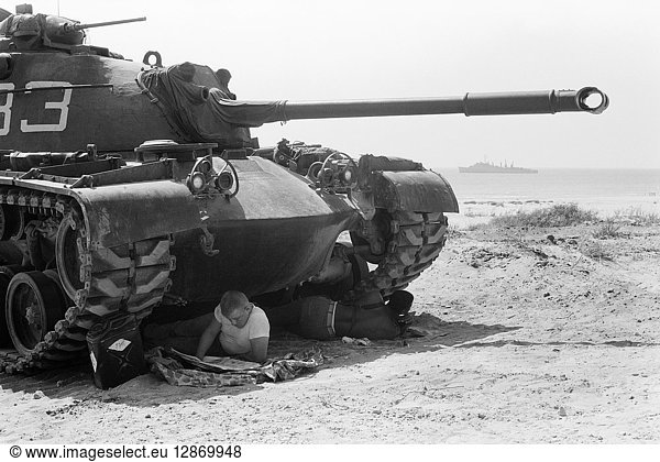 LEBANON CRISIS  1958. American marine  part of the intervention force dispatched to reinforce the Lebanese government  reads in the shade of a tank  Beirut  Lebanon. Photograph by Thomas J. O'Halloran  July 1958.