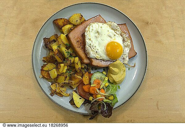 Leberkäs with fried egg and fried potatoes  in a Franconian restaurant  Bavaria  Germany  Europe