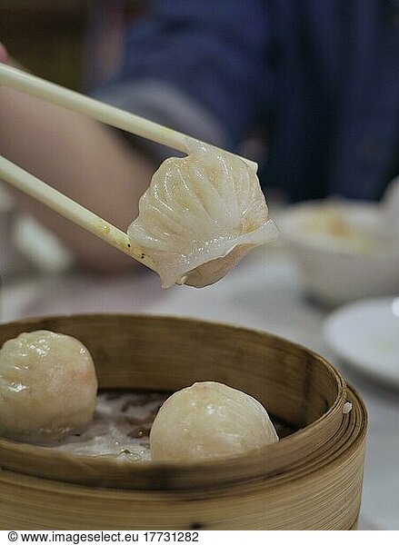 Leckere chinesische Dim Sum in einem chinesischen Restaurant  Stäbchen halten gedämpfte Krabbenrolle