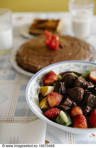 Leckere Früchte und Schokolade auf dem Tisch mit Geburtstagskuchen