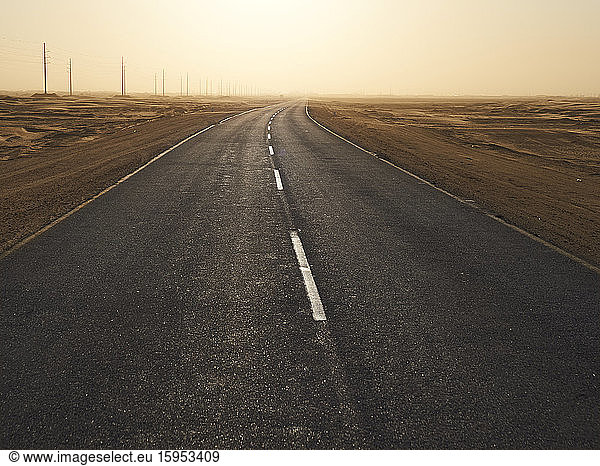 Leere Asphaltstraße in der Wüste bei Sonnenuntergang  Gebiet Solitaire  Namibia