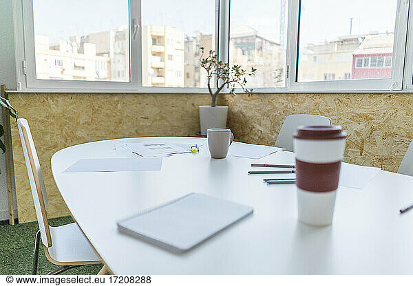 Leerer Konferenztisch mit Dokumenten und Kaffeetassen im Büro