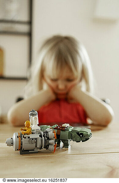 Lego figures in front of girl