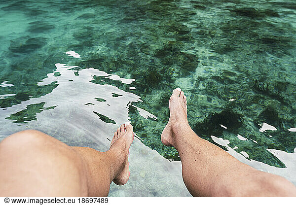 Legs of man above sea at vacation