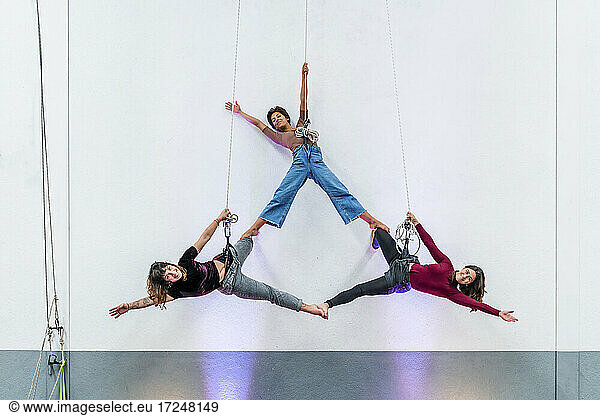 Leidenschaftliche Tänzerinnen üben gemeinsam an einem Seil hängend
