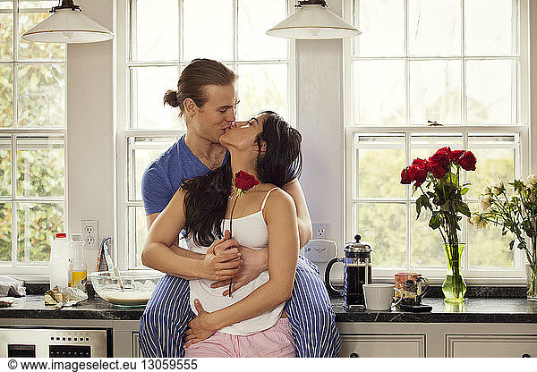 Leidenschaftliches Paar  das sich küsst  während es zu Hause an der Küchentheke steht