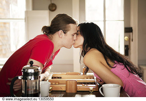 Leidenschaftliches Paar küsst sich am Tisch