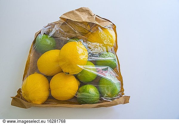 Lemons and limes in a plastic bag. Still life.