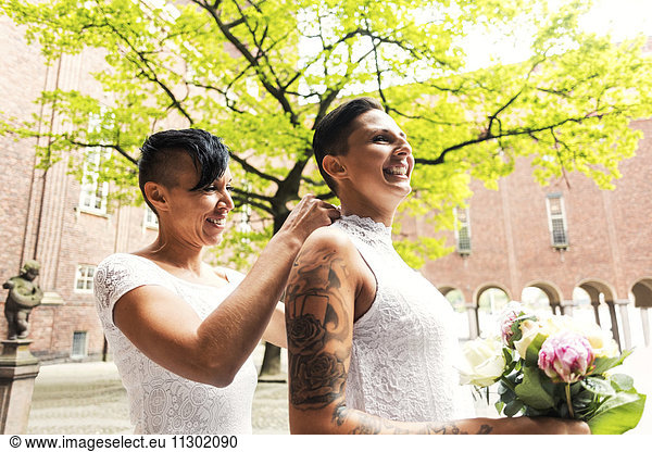 Lesbian couple getting dressed for wedding