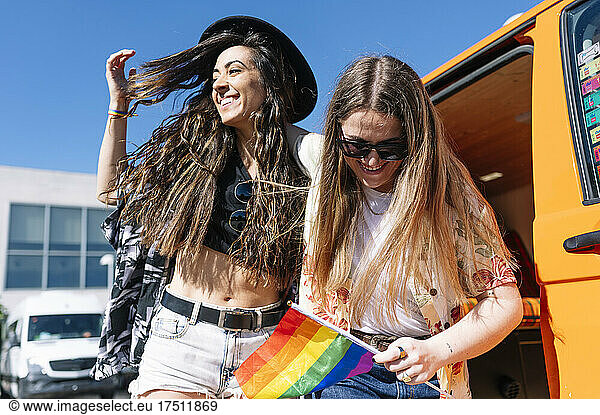 Lesbian couple with pride flag in front of camper