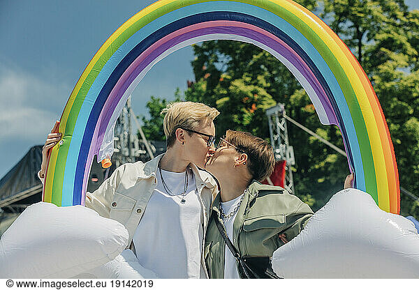 Lesbians with inflatable rainbow kissing each other