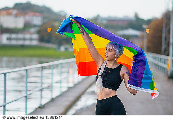 Lesbische Frau mit der Flagge des Stolzes in Sportkleidung