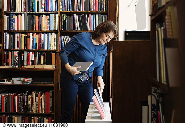 Librarian arranging books for display in antique shop