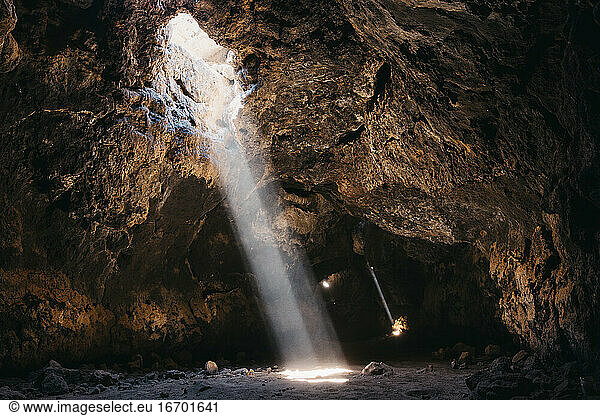 Lichtstrahlen durchdringen die dunkle vulkanische Höhle