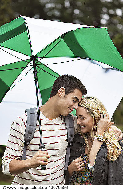 Liebespaar stehend mit Regenschirm