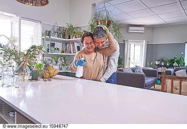Liebevolles  reifes Paar umarmt und putzt Kücheninsel
