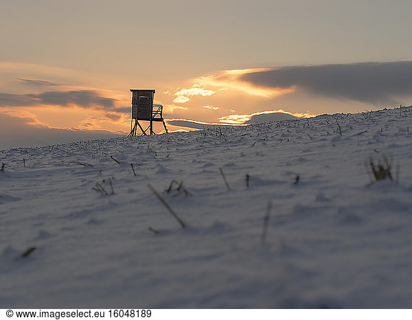 Lifeguard hut on snow-covered coast at dawn