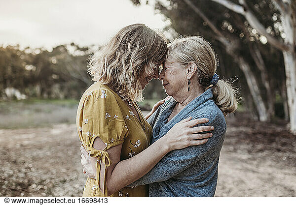 Lifestyle portrait of adult mother and senior mother embracing