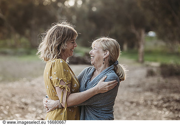 Lifestyle portrait of adult mother and senior mother looking at each o