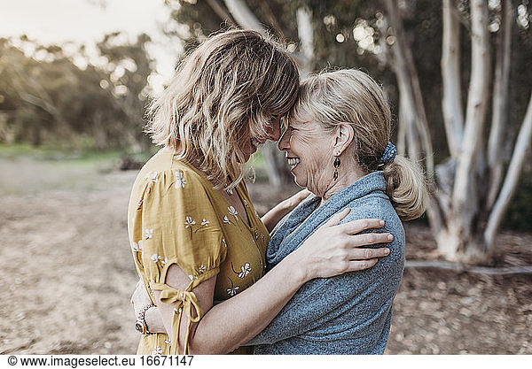 Lifestyle portrait of adult mother and senior mother smiling