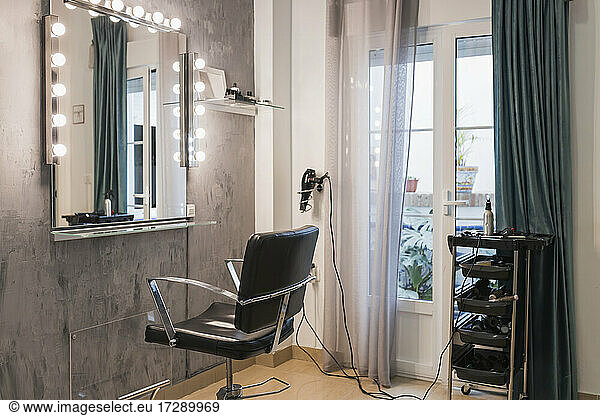 Light bulbs on mirror by chair at hair salon