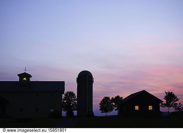 Light glow inside a Vermont farmhouse at dusk along the shore of Lake Champlain