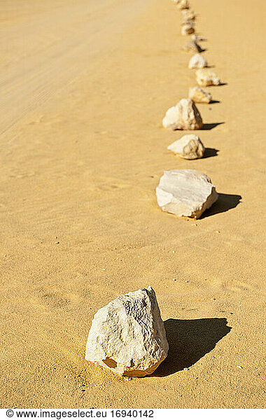 Linie von Steinen im Sand.