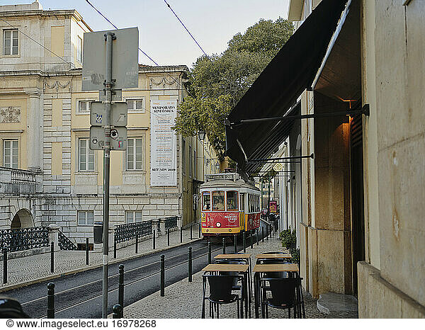 Lisbon tram going past restaurant and theater