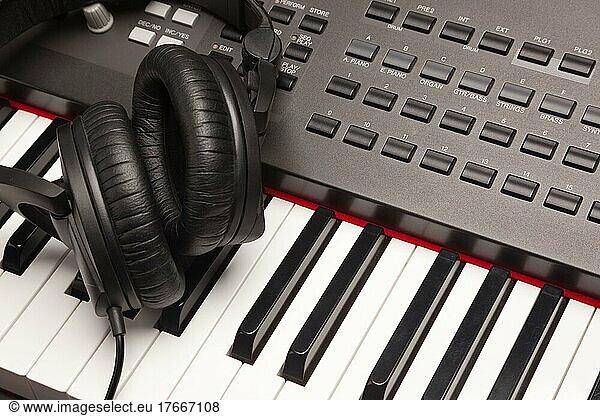 Listening headphones laying on electronic synthesizer keyboard