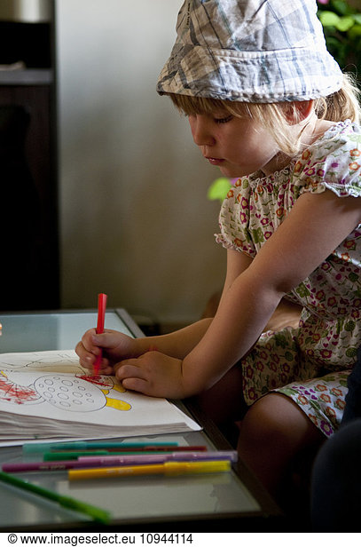 Little adorable girl drawing on paper