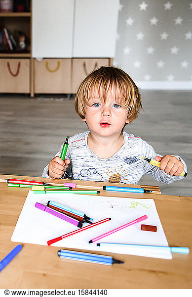 Little boy drawing with felt-tip pens