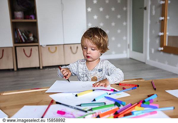 Little boy drawing with felt-tip pens
