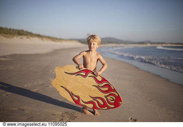 Little boy holding sandboard on the beach  Viana do Castelo  Norte Region  Portugal