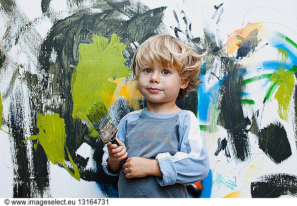 Little boy in front of his painting